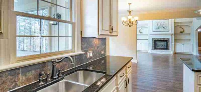 Spacious kitchen with granite countertops, stainless steel sink, and elegant chandelier lighting., tags: zum - pexel